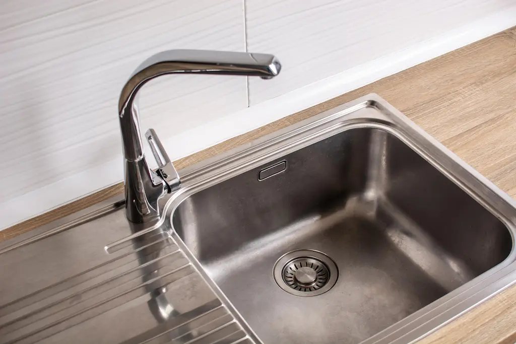 Stainless steel kitchen sink with modern chrome faucet