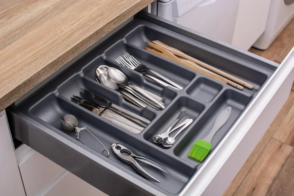 Stainless pot on gas cooktop with utensils in the background