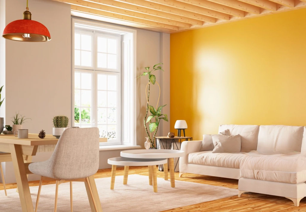 Living room with yellow accent wall and beige furniture.