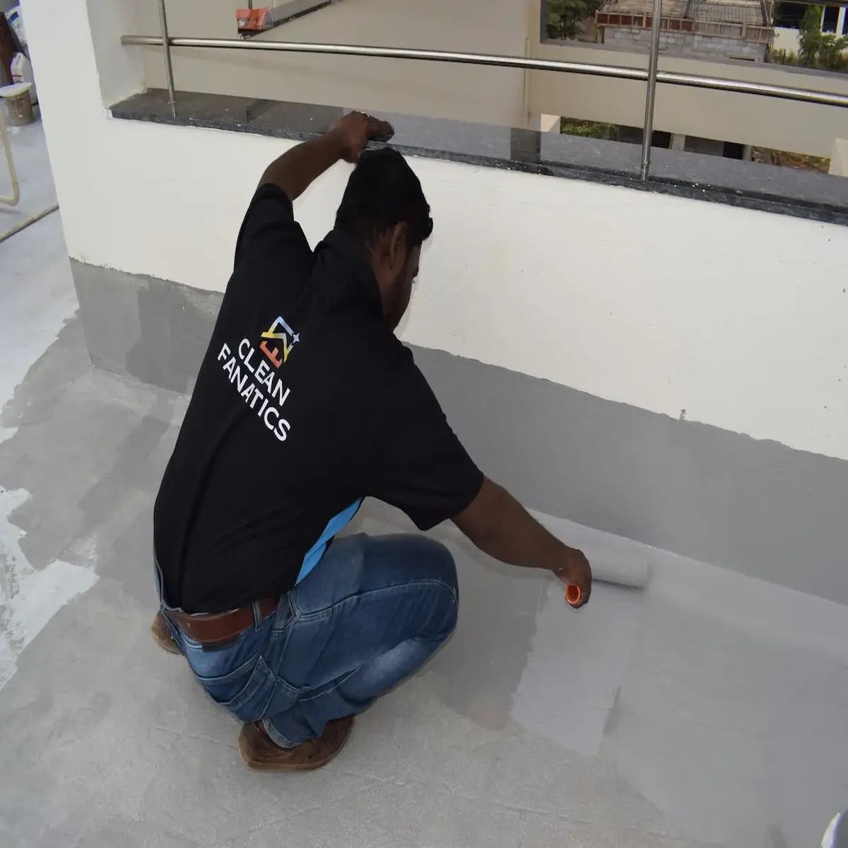Clean Fanatics Technician applying waterproof coating on terrace floor