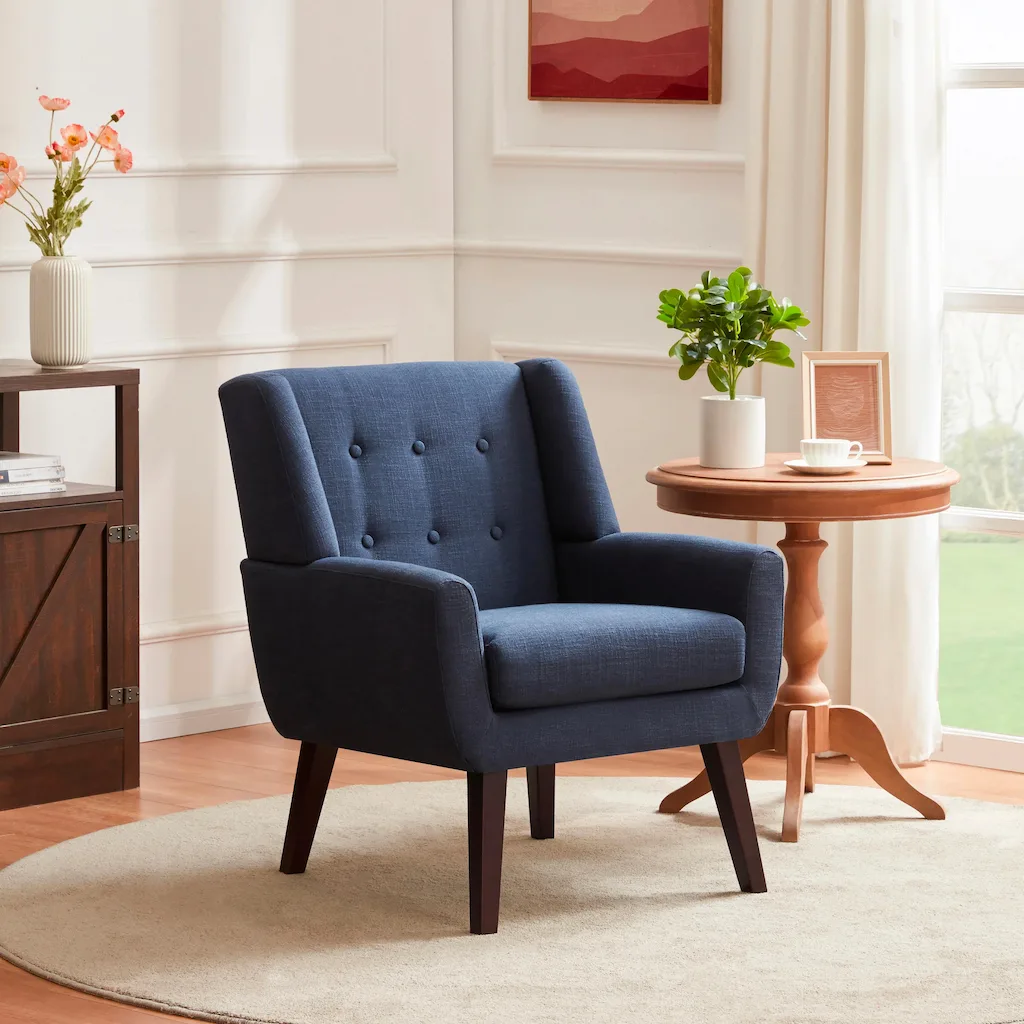A stylish blue armchair in a cozy living room with a side table, plant, and cup